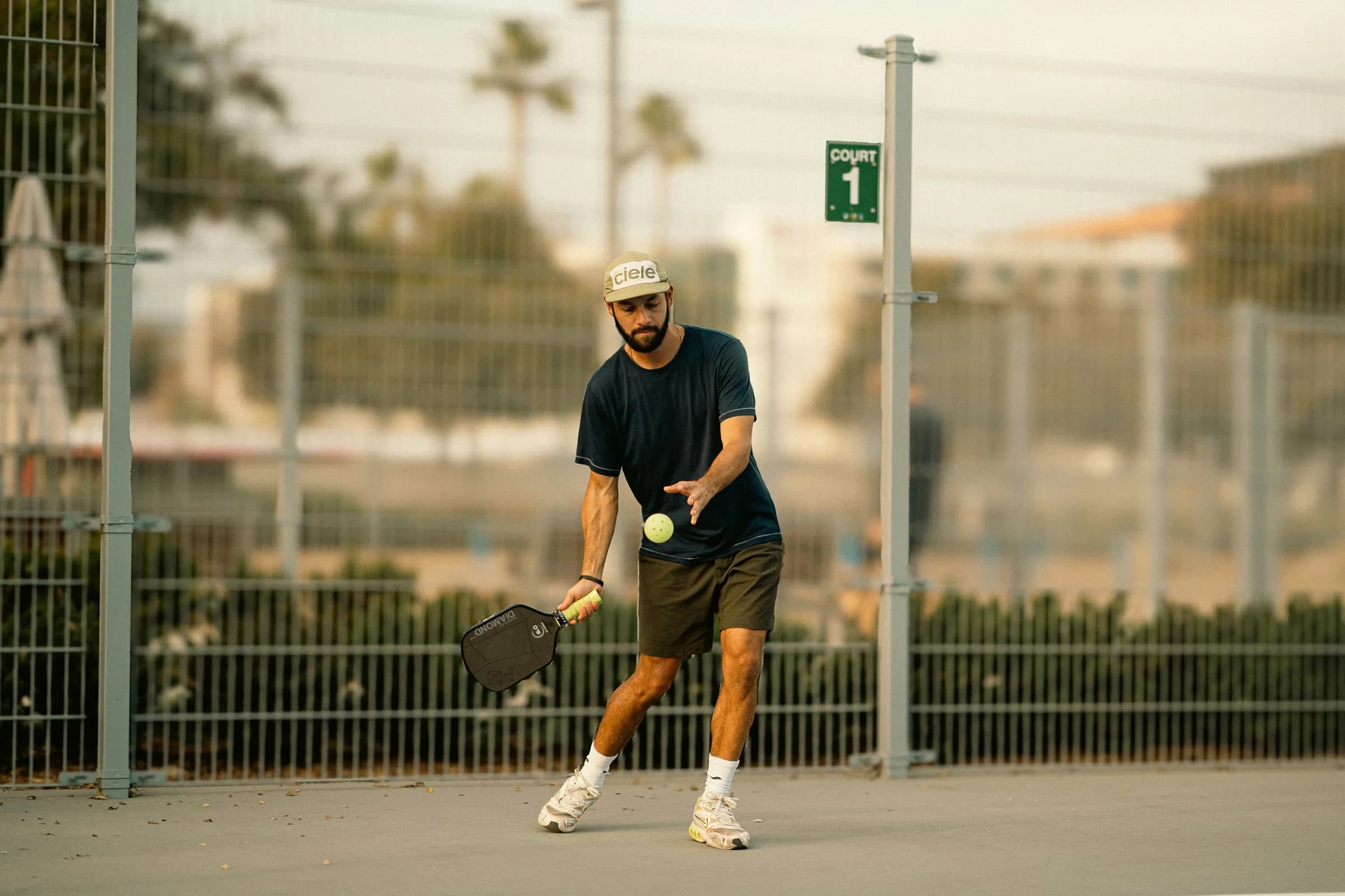 A player preparing an underarm pickleball serve
